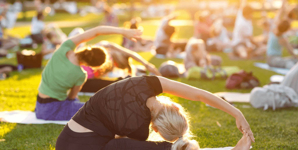 Женщина занимается йогой на природе у озера