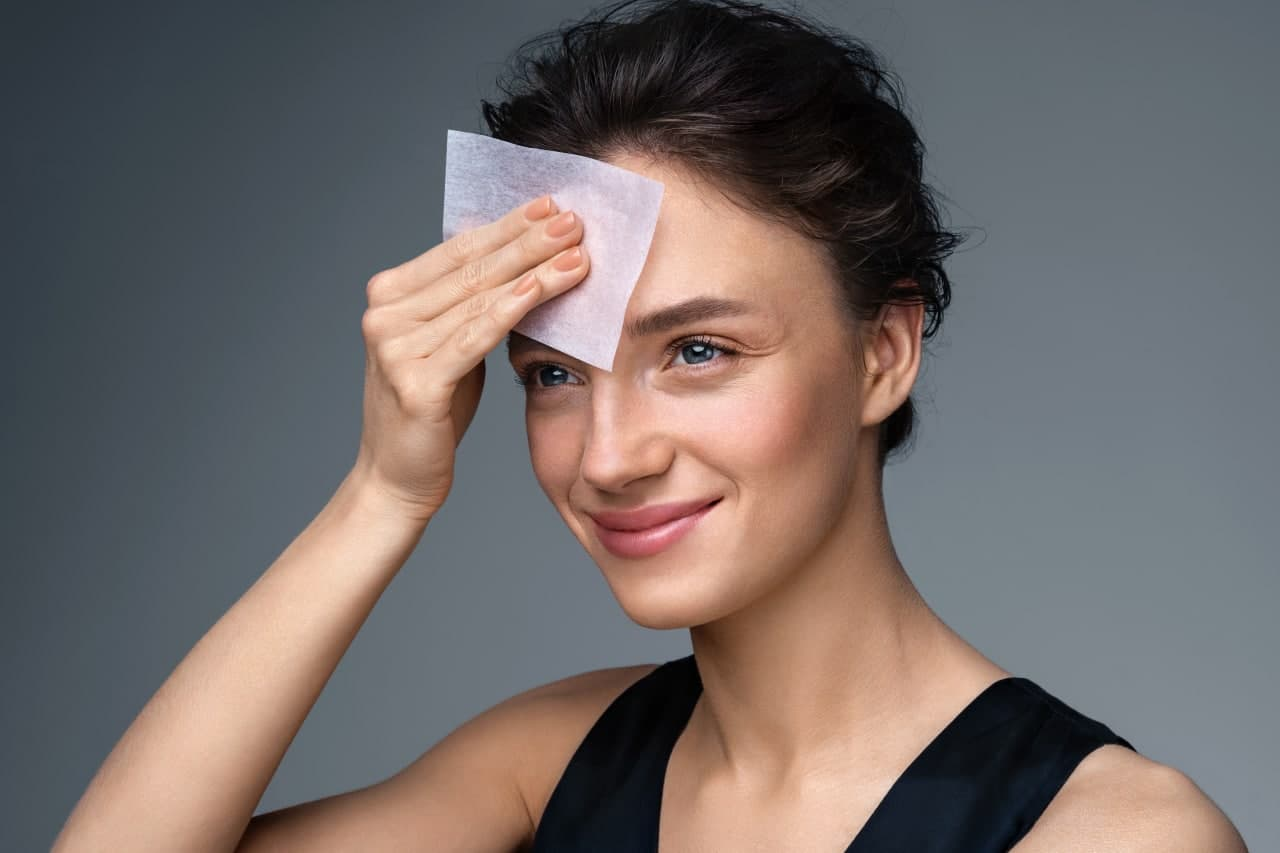 Женщина, которая наносит тональный крем на лицо