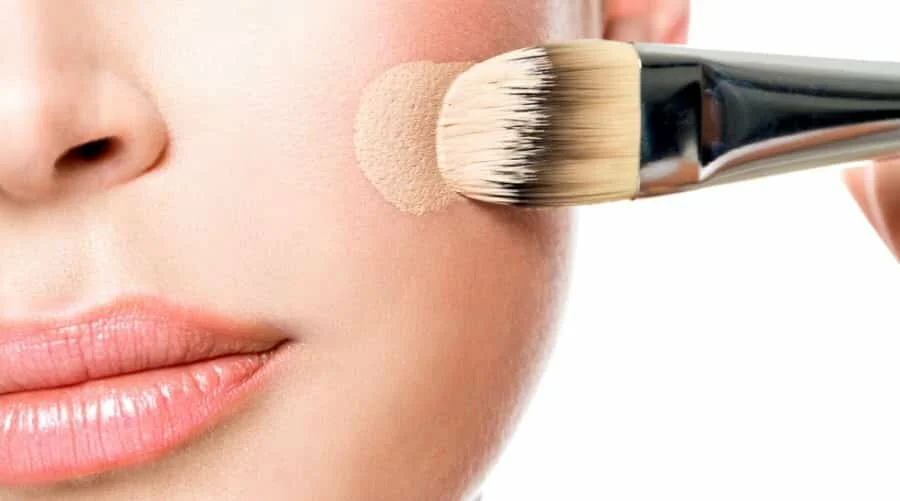 Женщина, наносящая консилер на лицо